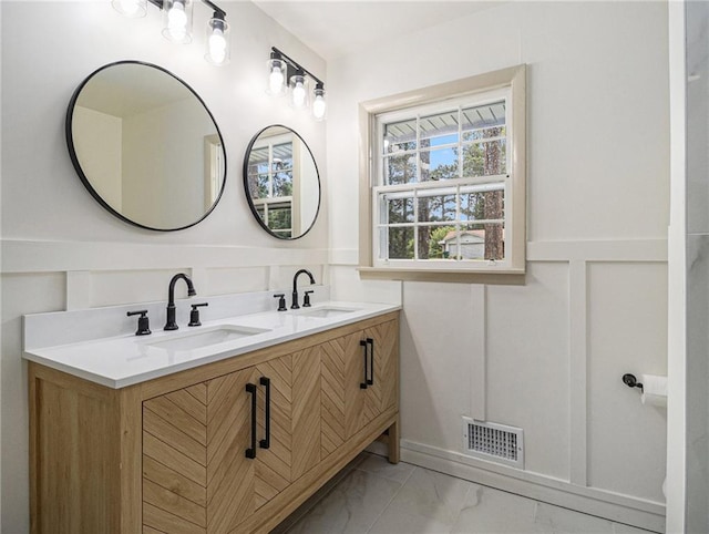 full bathroom featuring wainscoting, visible vents, marble finish floor, and a sink