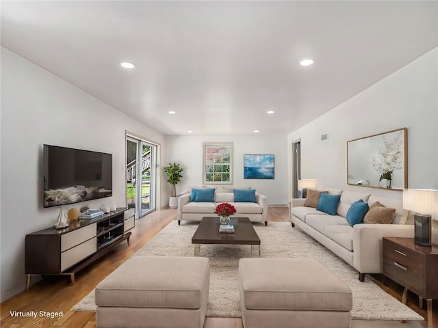 living area featuring recessed lighting, visible vents, and wood finished floors