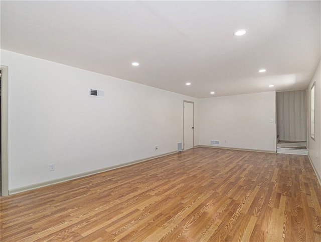 empty room featuring recessed lighting, light wood-style floors, visible vents, and baseboards