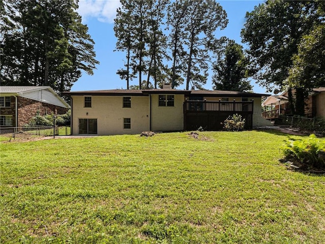 back of house featuring a yard and fence