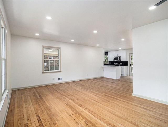 unfurnished living room featuring recessed lighting, visible vents, and light wood-type flooring