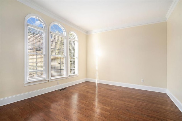 spare room with dark hardwood / wood-style floors, ornamental molding, and plenty of natural light