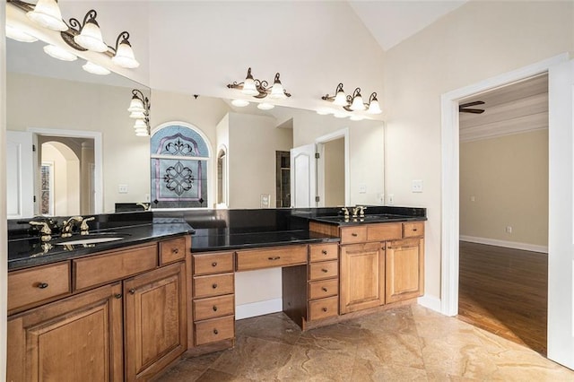 bathroom with lofted ceiling, vanity, and ceiling fan