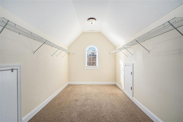 spacious closet with light carpet and lofted ceiling