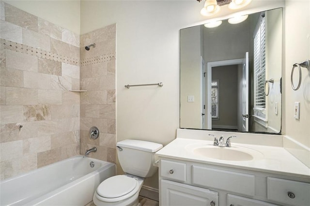 full bathroom featuring toilet, tiled shower / bath, and vanity