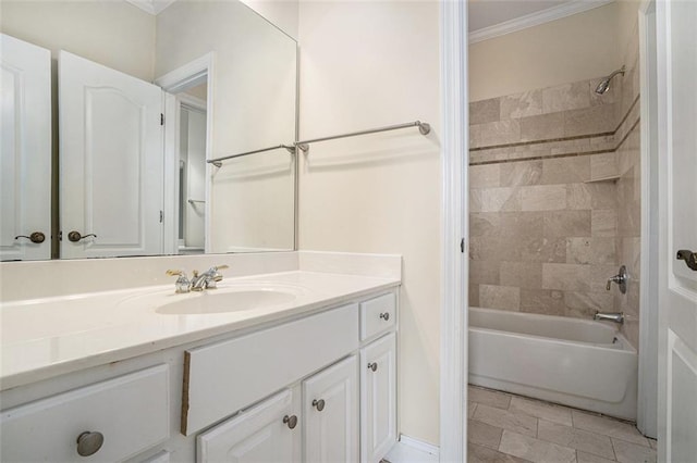 bathroom with ornamental molding, tiled shower / bath, and vanity