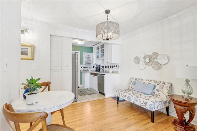 dining area with a notable chandelier, crown molding, and light hardwood / wood-style floors