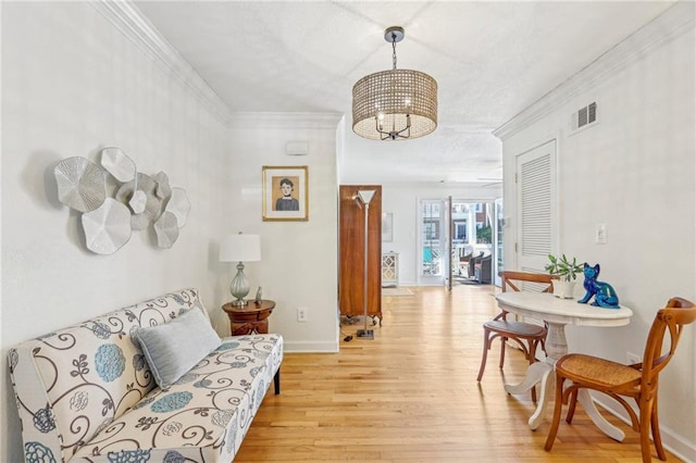 living area featuring ornamental molding and light wood-type flooring