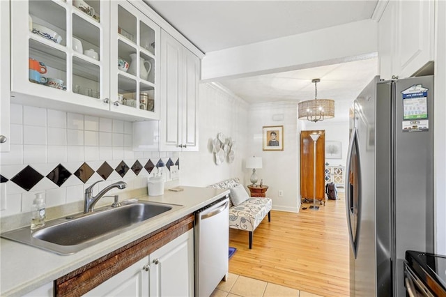 kitchen featuring sink, hanging light fixtures, white cabinets, and stainless steel appliances