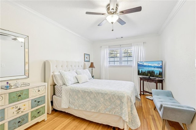 bedroom with ceiling fan, crown molding, and light wood-type flooring