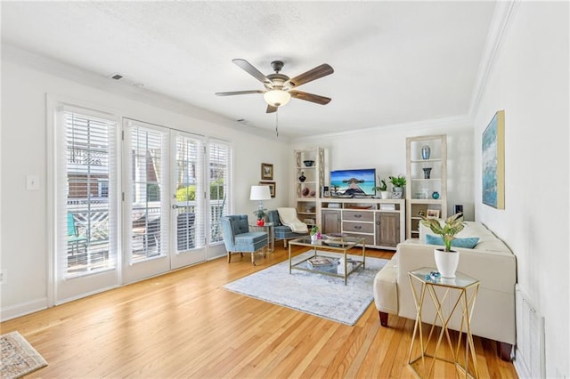 living room featuring ceiling fan, wood-type flooring, and ornamental molding