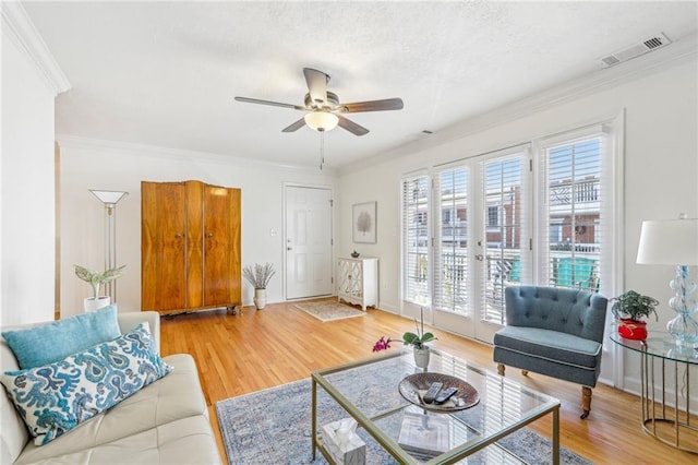 living room featuring ceiling fan, hardwood / wood-style floors, crown molding, and french doors