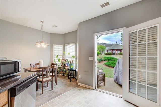 interior space featuring light carpet, a notable chandelier, visible vents, and baseboards