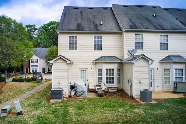 rear view of property featuring a yard and central AC unit
