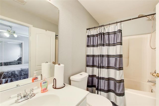 ensuite bathroom featuring vanity, a ceiling fan, visible vents, toilet, and shower / bath combo