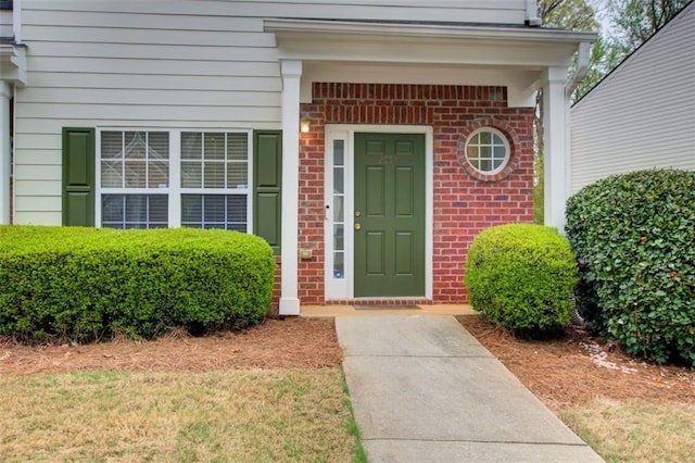 property entrance featuring brick siding