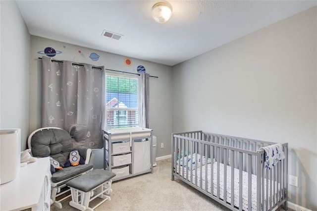 bedroom featuring a crib, carpet, visible vents, and baseboards