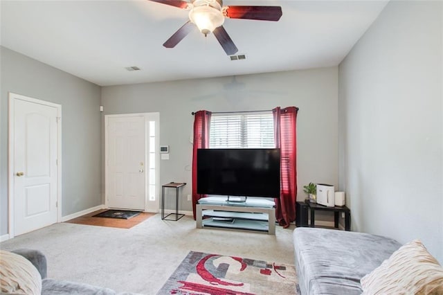 carpeted living area featuring visible vents, baseboards, and ceiling fan