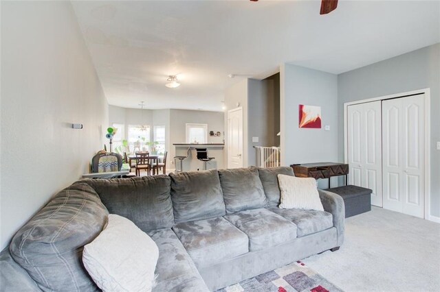 living area with ceiling fan and carpet flooring
