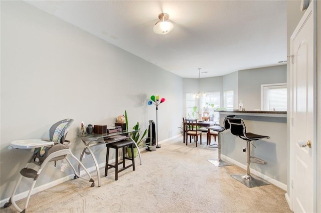 carpeted office space with baseboards and a notable chandelier