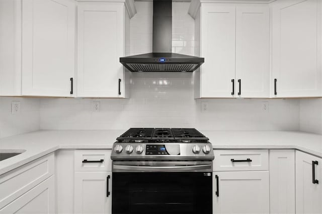 kitchen with white cabinetry, wall chimney exhaust hood, tasteful backsplash, and gas stove