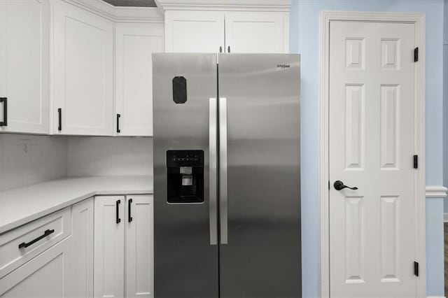 kitchen with backsplash, stainless steel fridge with ice dispenser, and white cabinets