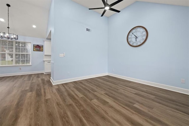 unfurnished room featuring ceiling fan with notable chandelier, high vaulted ceiling, and dark hardwood / wood-style flooring