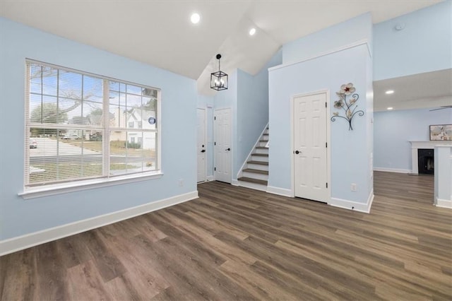 interior space featuring dark hardwood / wood-style flooring, lofted ceiling, and a notable chandelier