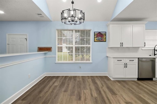 unfurnished dining area with dark hardwood / wood-style flooring, lofted ceiling, and an inviting chandelier