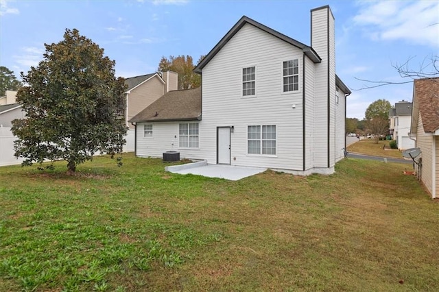 rear view of house with cooling unit, a yard, and a patio area