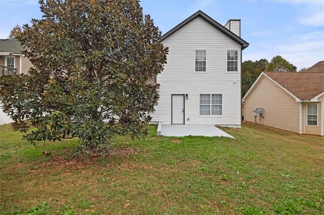 rear view of property featuring a patio area and a lawn