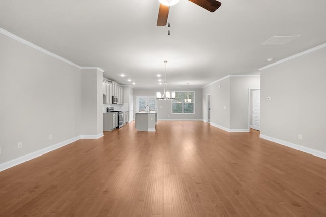 unfurnished living room featuring baseboards, ornamental molding, recessed lighting, ceiling fan with notable chandelier, and wood finished floors