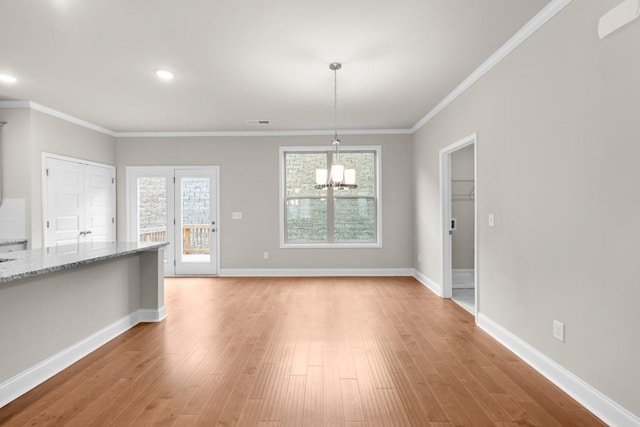 unfurnished dining area with visible vents, baseboards, light wood finished floors, and a notable chandelier