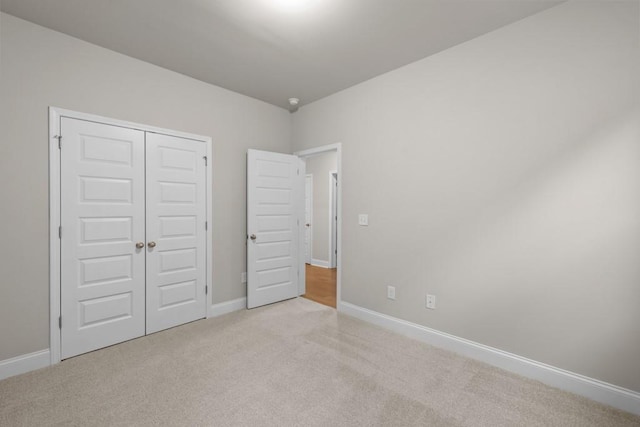 unfurnished bedroom with a closet, baseboards, and carpet floors