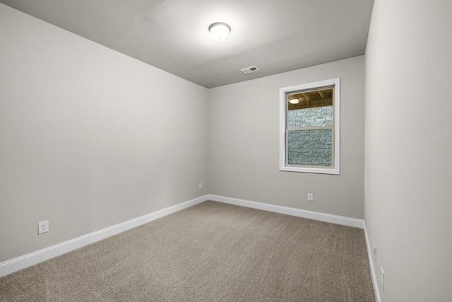 carpeted spare room with visible vents and baseboards