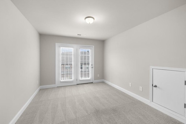 unfurnished room with visible vents, baseboards, and light colored carpet