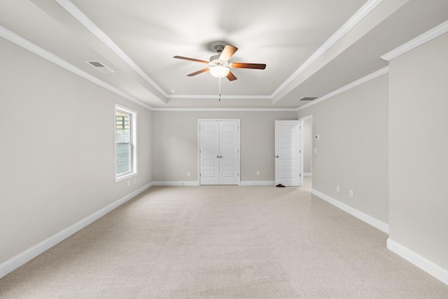 unfurnished bedroom with a raised ceiling, light colored carpet, and visible vents