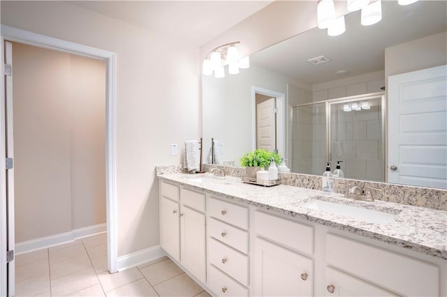 bathroom with double vanity, tile patterned flooring, a sink, and a shower stall