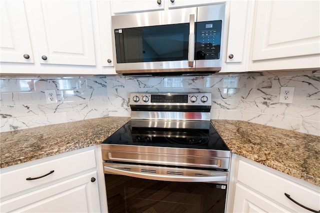 1200 Martins Chapel Ln SE, Lawrenceville, GA 30045 - kitchen featuring appliances with stainless steel finishes, white cabinetry, decorative backsplash, and dark stone counters