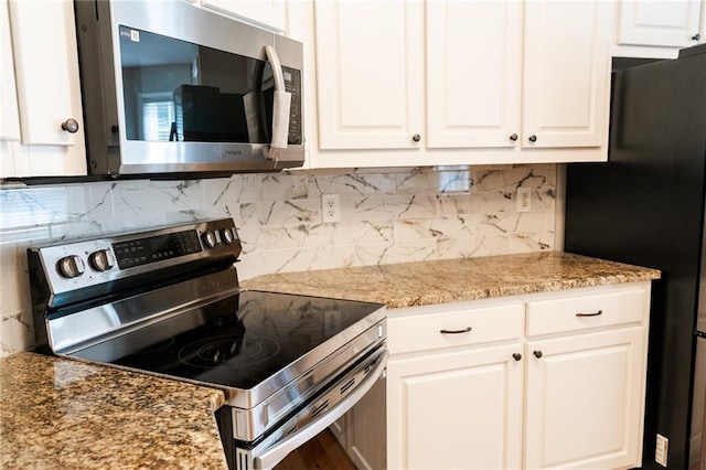 1200 Martins Chapel Ln SE, Lawrenceville, GA 30045 - kitchen featuring appliances with stainless steel finishes, decorative backsplash, white cabinets, and light stone countertops