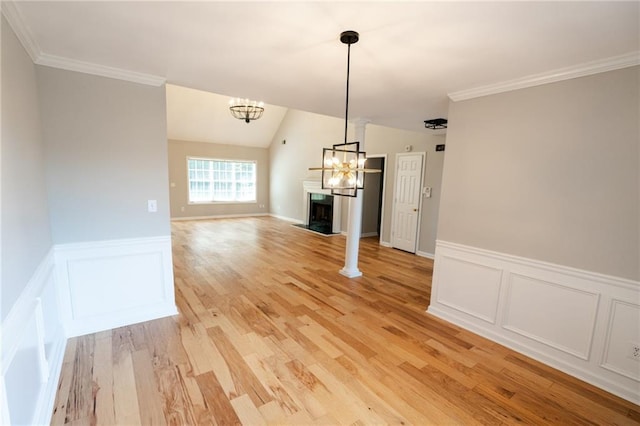 1200 Martins Chapel Ln SE, Lawrenceville, GA 30045 - unfurnished dining area featuring a chandelier, light wood finished floors, a decorative wall, a fireplace with raised hearth, and a wainscoted wall