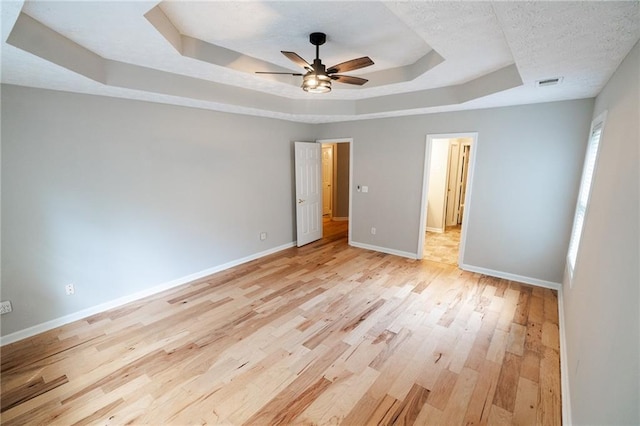 1200 Martins Chapel Ln SE, Lawrenceville, GA 30045 - unfurnished bedroom featuring a raised ceiling, light wood-style flooring, a ceiling fan, and a textured ceiling