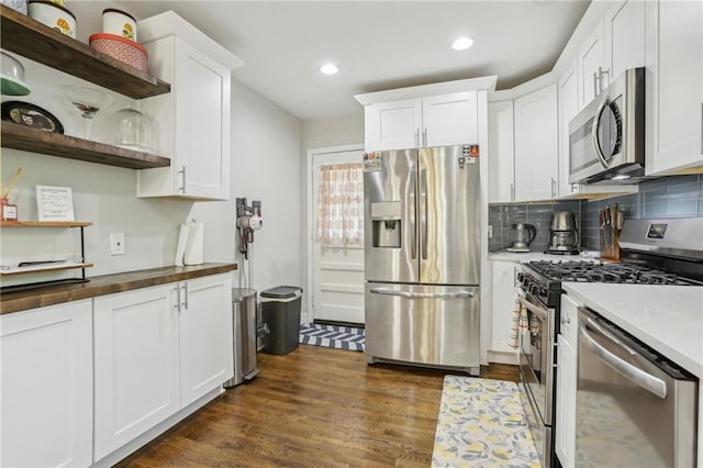 kitchen with tasteful backsplash, dark wood-style floors, white cabinetry, open shelves, and appliances with stainless steel finishes