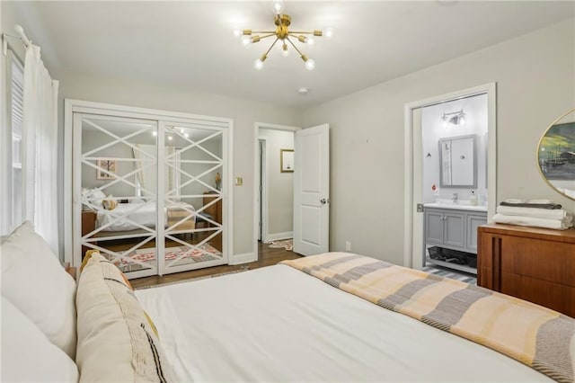 bedroom with ensuite bathroom, baseboards, and an inviting chandelier