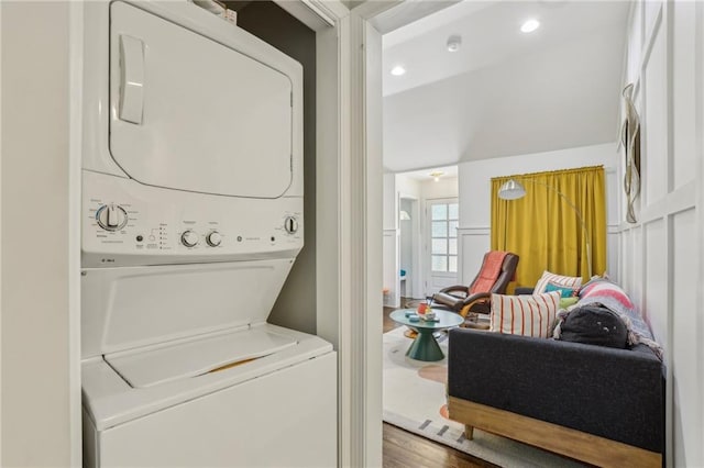 laundry room featuring recessed lighting, stacked washer / dryer, and laundry area