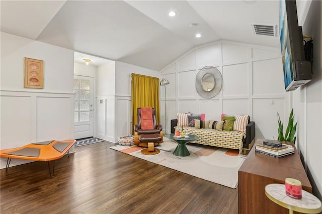 interior space with a decorative wall, vaulted ceiling, visible vents, recessed lighting, and wood finished floors