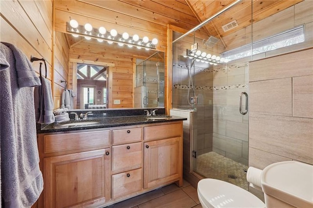 bathroom featuring wooden walls, a shower with shower door, lofted ceiling, tile patterned flooring, and vanity