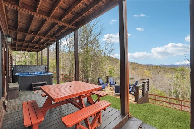 deck featuring a hot tub and a fire pit