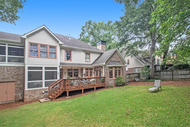 back of property featuring a wooden deck and a lawn