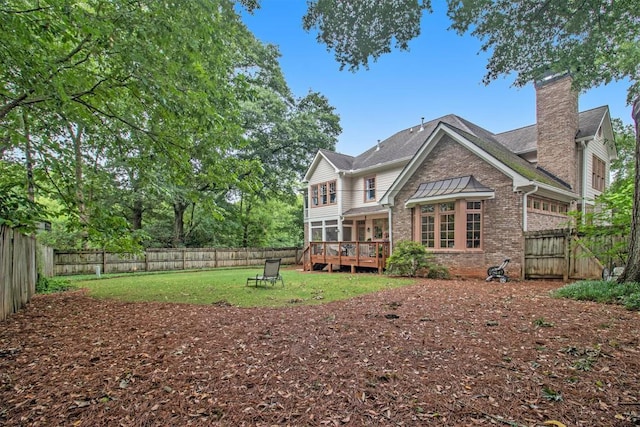 rear view of house featuring a deck and a lawn